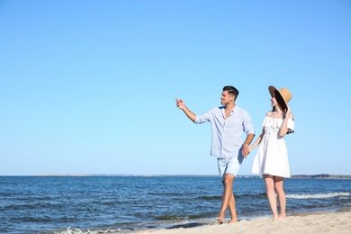 Photo of Lovely couple walking on beach. Space for text