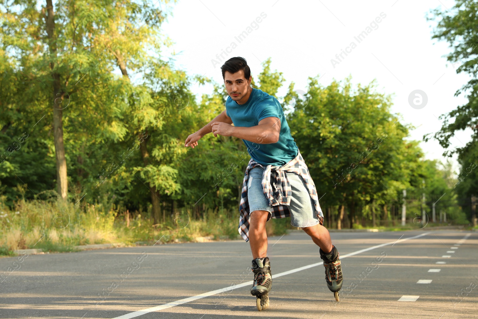 Photo of Handsome young man roller skating in park