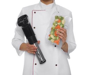 Photo of Chef holding sous vide cooker and vegetables in vacuum pack on white background, closeup