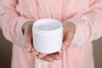 Photo of Woman with jar of moisturizing cream, closeup