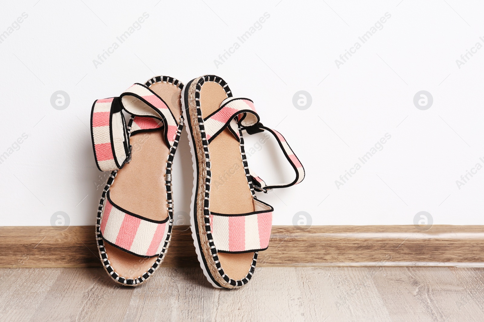 Photo of Pair of female shoes on floor against white wall