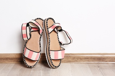 Photo of Pair of female shoes on floor against white wall