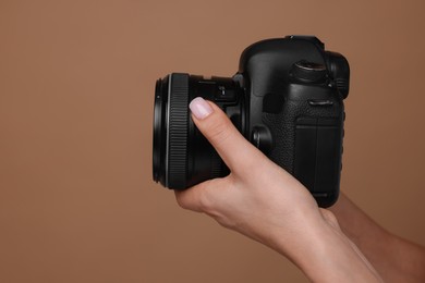 Photo of Photographer with camera on brown background, closeup