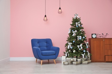 Stylish room interior with decorated Christmas tree