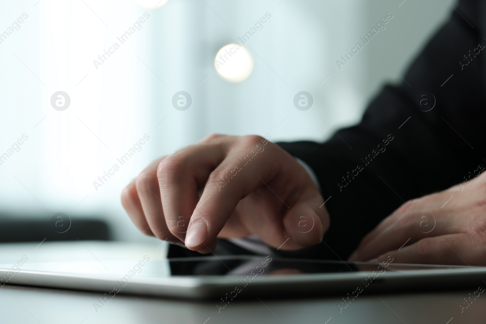 Photo of Closeup view of man using new tablet at desk indoors