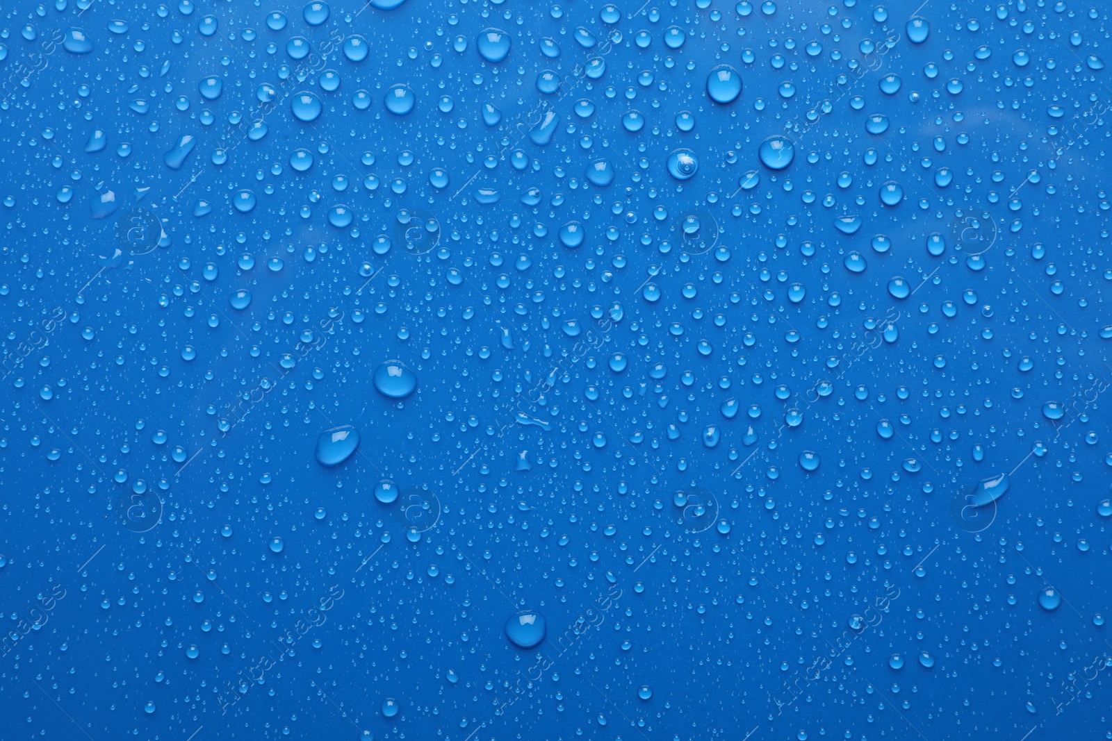 Photo of Water drops on blue background, top view