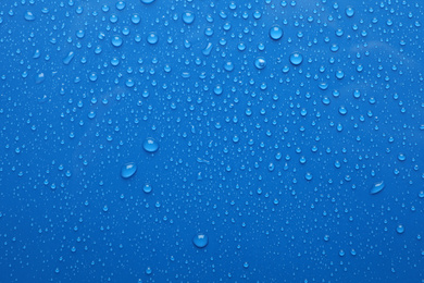 Water drops on blue background, top view