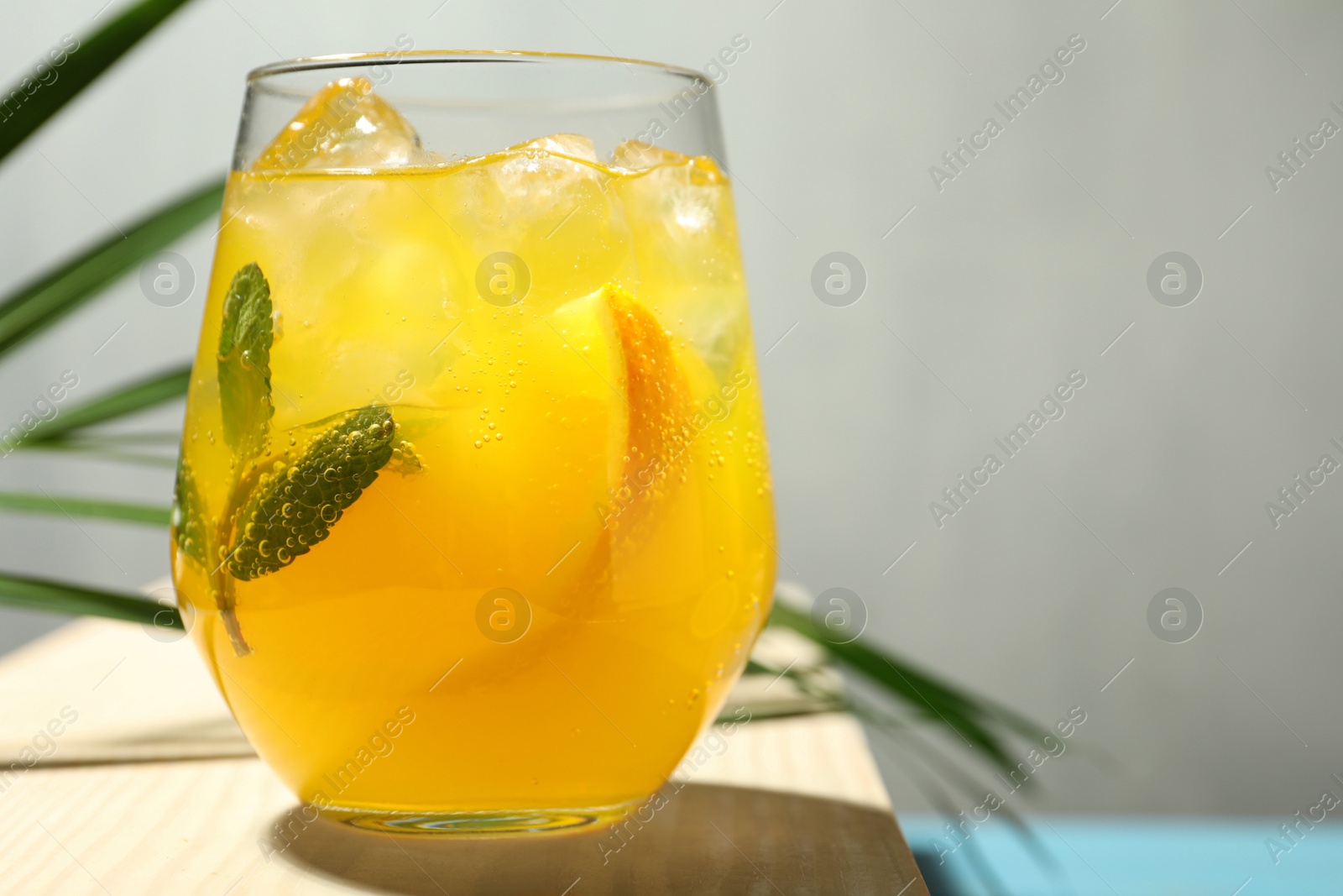 Photo of Delicious orange soda water on wooden table, closeup