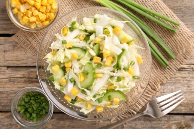 Photo of Tasty salad with Chinese cabbage served on wooden table, flat lay