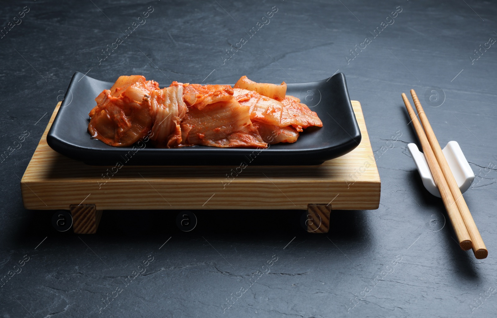 Photo of Delicious kimchi with Chinese cabbage served on grey table