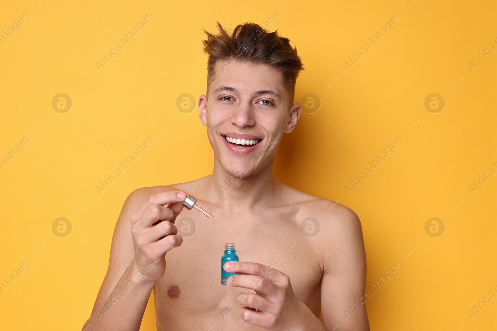 Photo of Handsome man with serum on orange background