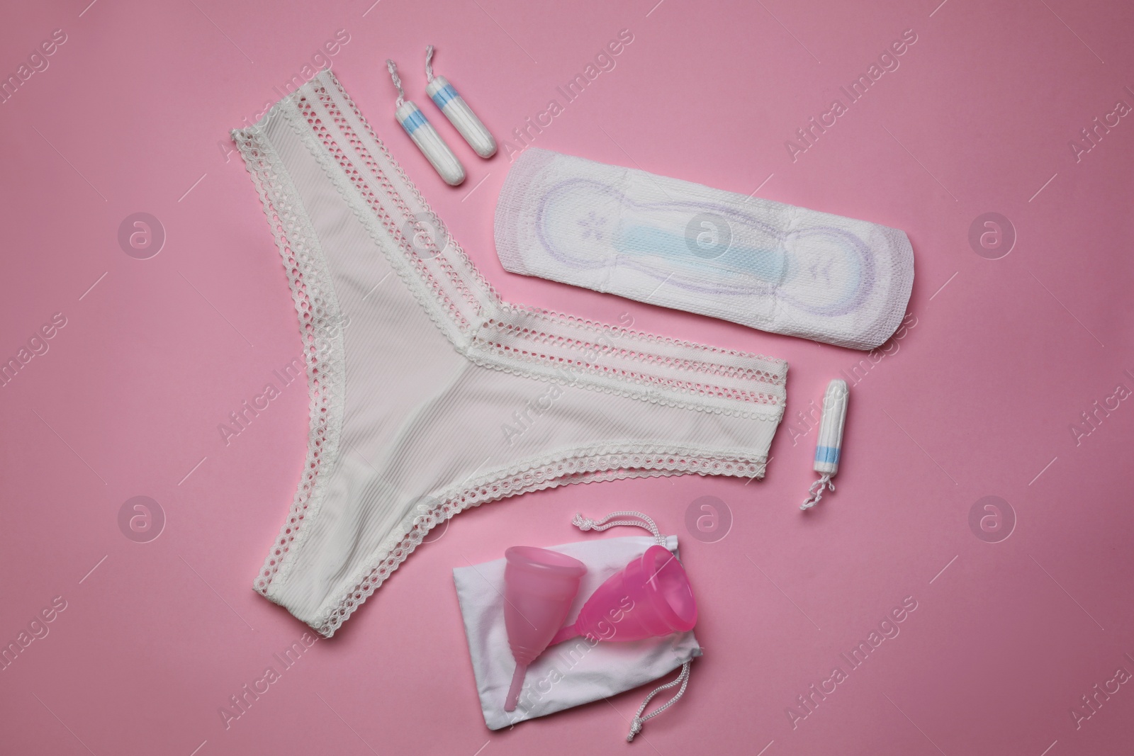 Photo of Flat lay composition with woman's panties and menstrual hygiene products on pink background