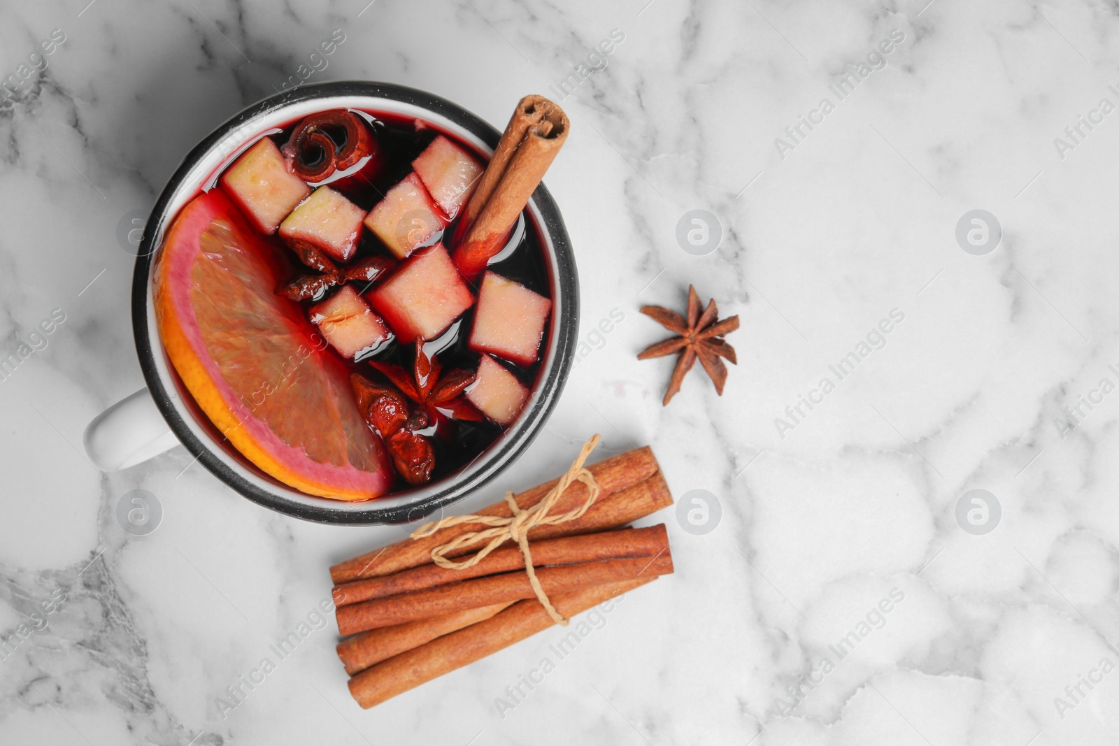 Photo of Flat lay composition with mug of hot mulled wine and space for text on marble background