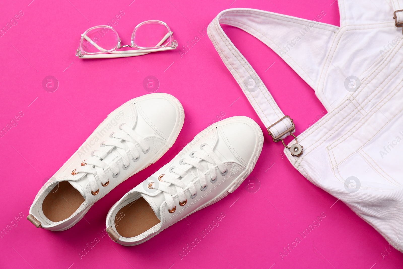 Photo of Comfortable casual female shoes, jumpsuit and glasses on color background