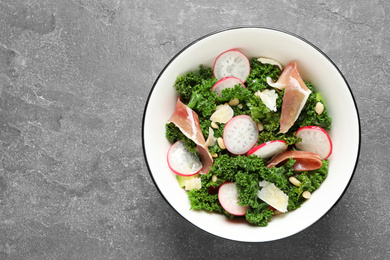 Photo of Tasty fresh kale salad on grey table, top view. Space for text