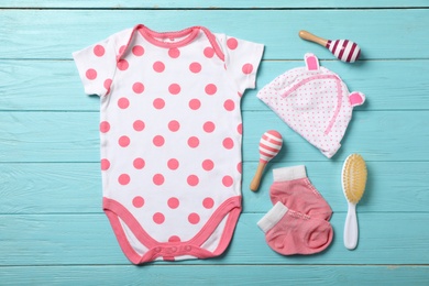Photo of Flat lay composition with stylish baby clothes on wooden background