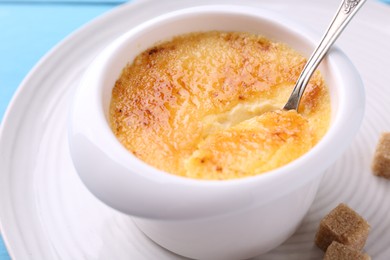 Photo of Delicious creme brulee in bowl served on table, closeup