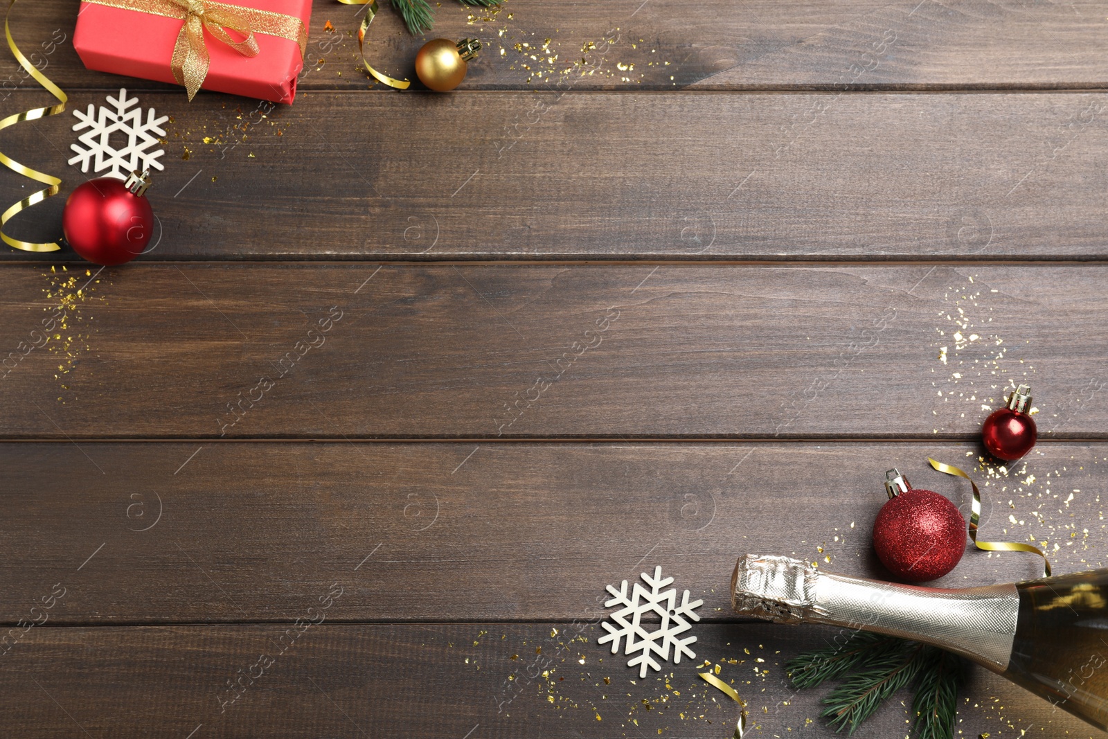 Photo of Flat lay composition with bottle of sparkling wine and festive decor on wooden background, space for text. Happy New Year