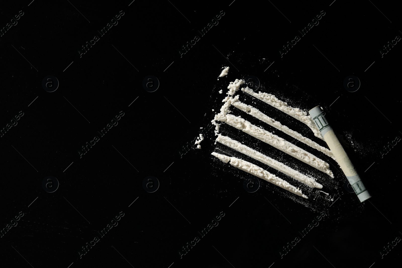 Photo of Hard drug and rolled dollar banknote on black background,, flat lay. Space for text