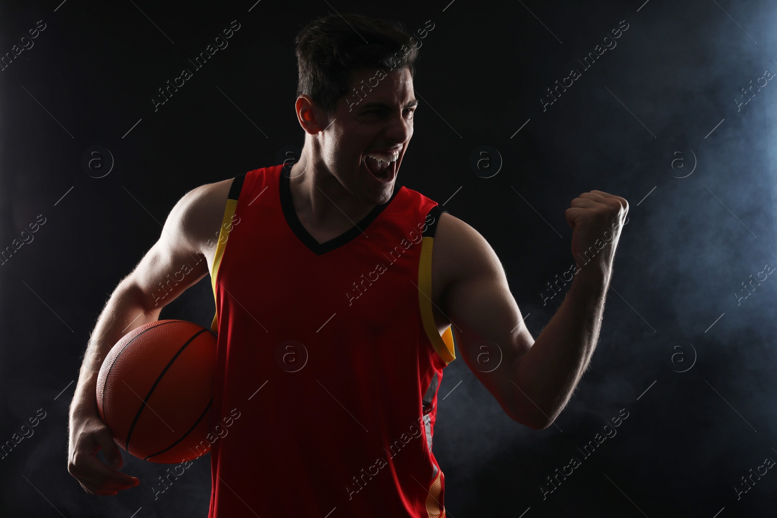 Photo of Basketball player with ball on black background