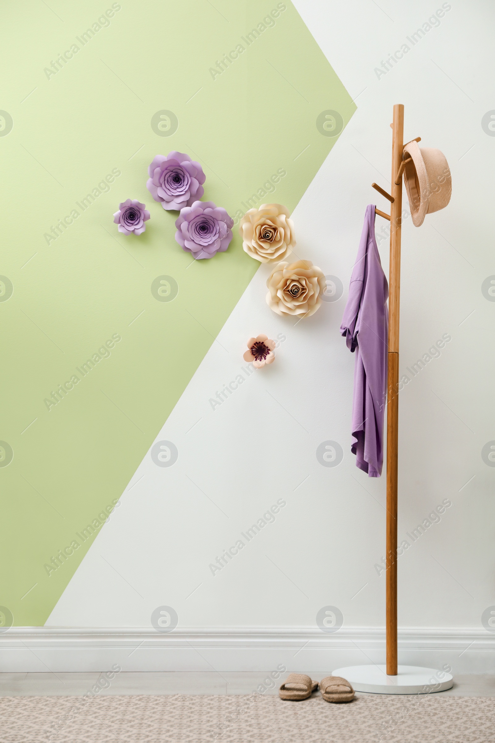 Photo of Stylish room interior with clothes rack and floral decor on wall