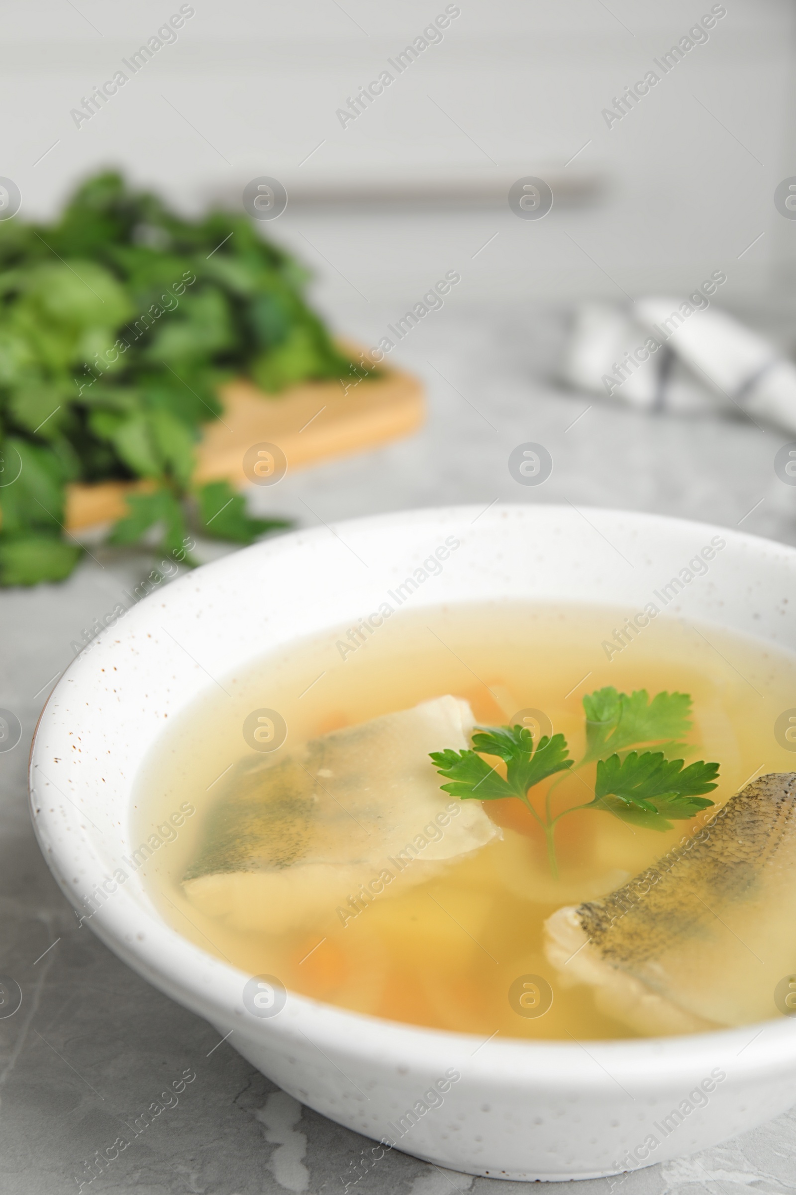 Photo of Delicious fish soup served on marble table