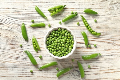 Photo of Flat lay composition with green peas on wooden background