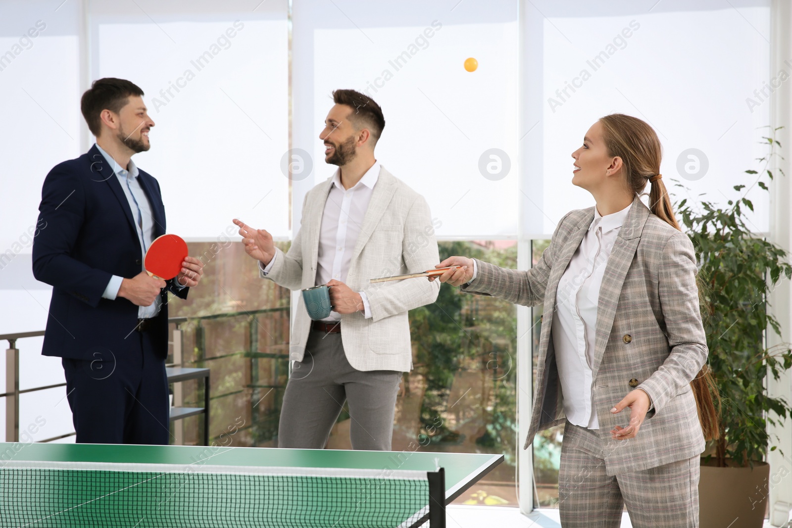 Photo of Business people talking near ping pong table in office