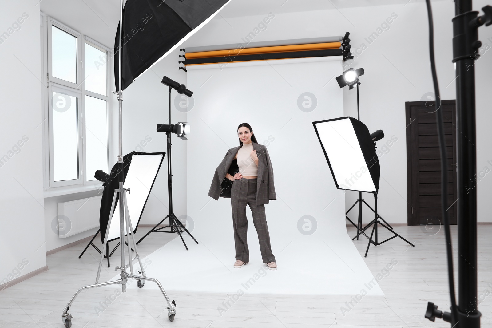 Photo of Beautiful young model posing in modern studio. Professional photo session