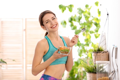 Young woman in fitness clothes having healthy breakfast at home