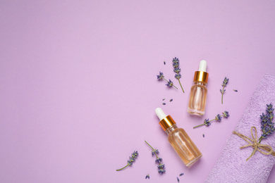 Photo of Flat lay composition with lavender flowers and natural essential oil on pink background. Space for text