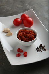 Photo of Red curry paste and ingredients on grey table