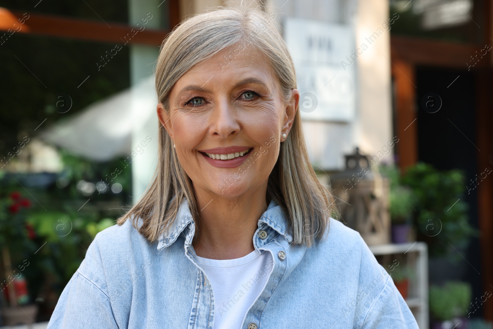 Photo of Portrait of happy business owner near her flower shop outdoors