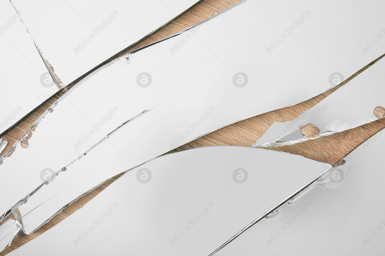 Photo of Shards of broken mirror on wooden background, top view