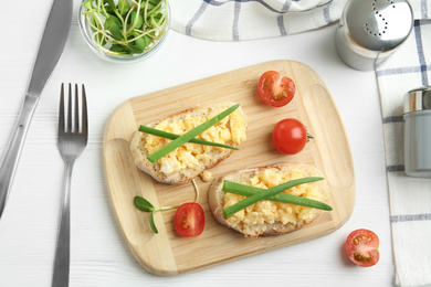 Tasty scrambled egg sandwiches served on white wooden table, flat lay