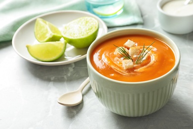 Bowl of tasty sweet potato soup on table. Space for text