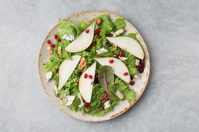 Photo of Plate with delicious pear salad on grey textured table, top view