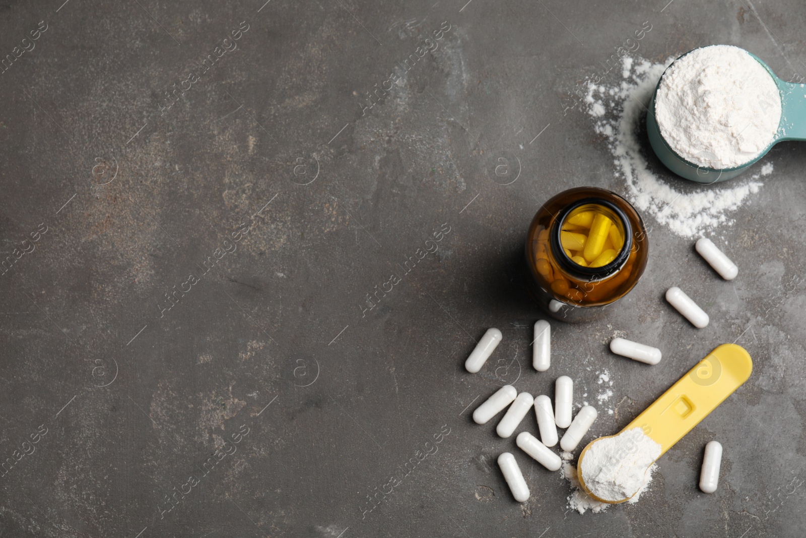 Photo of Amino acid pills and powder on grey table, flat lay. Space for text