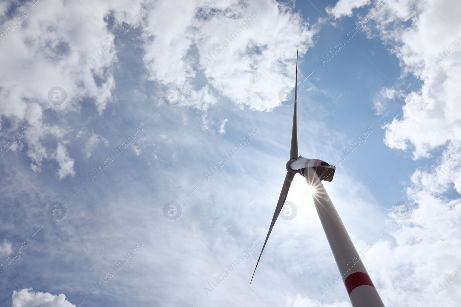 Photo of Modern wind turbine against cloudy sky, low angle view. Alternative energy source