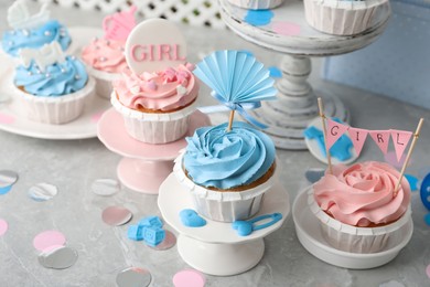 Photo of Delicious cupcakes with light blue and pink cream for baby shower on grey table