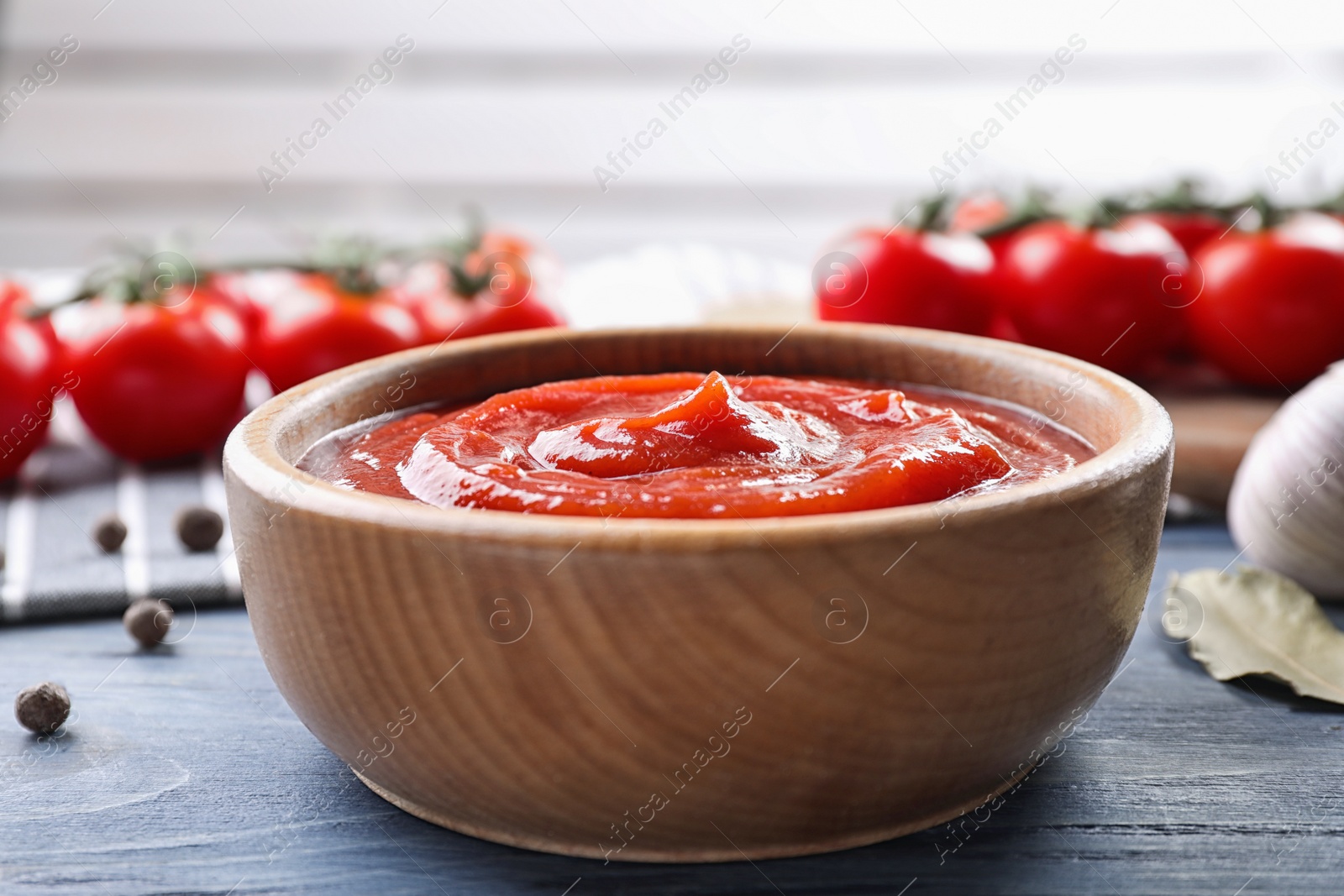 Photo of Delicious fresh tomato sauce on blue wooden table, closeup