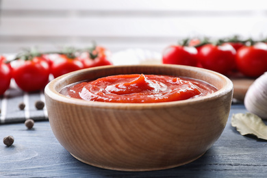 Photo of Delicious fresh tomato sauce on blue wooden table, closeup