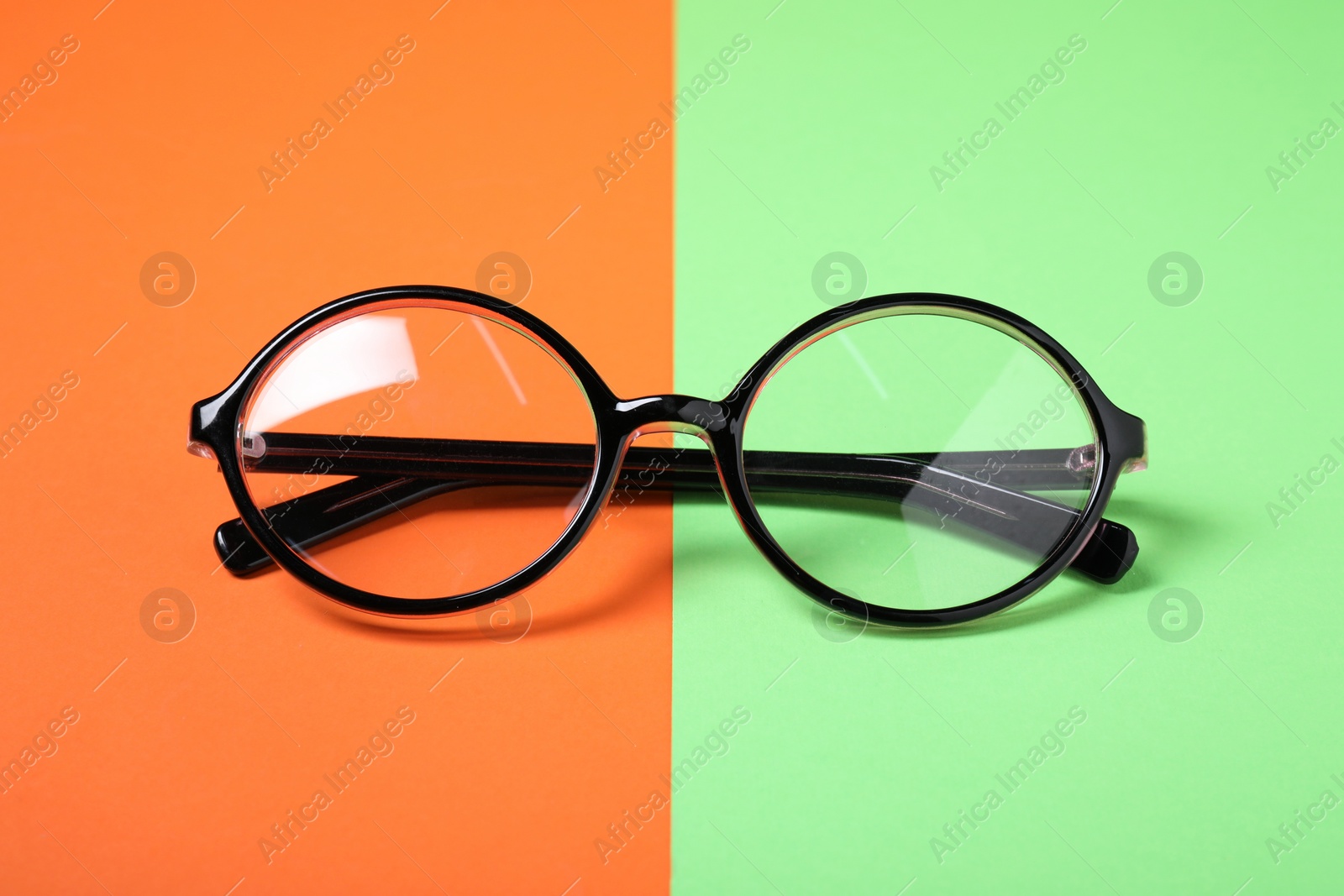 Photo of Glasses in stylish frame on color background