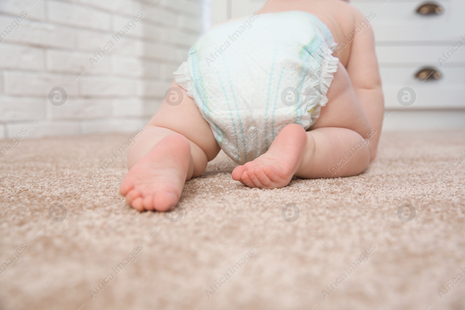 Photo of Cute little baby crawling on carpet indoors, closeup