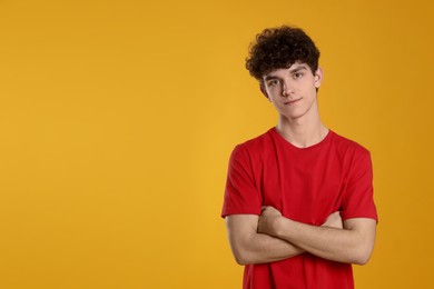 Photo of Portrait of cute teenage boy on orange background. Space for text