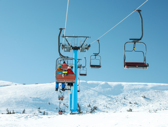 Photo of People using chairlift at mountain ski resort. Winter vacation