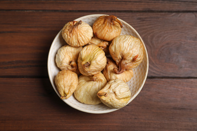 Photo of Tasty dried figs on  wooden table, top view