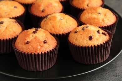 Photo of Delicious freshly baked muffins with chocolate chips on table, closeup