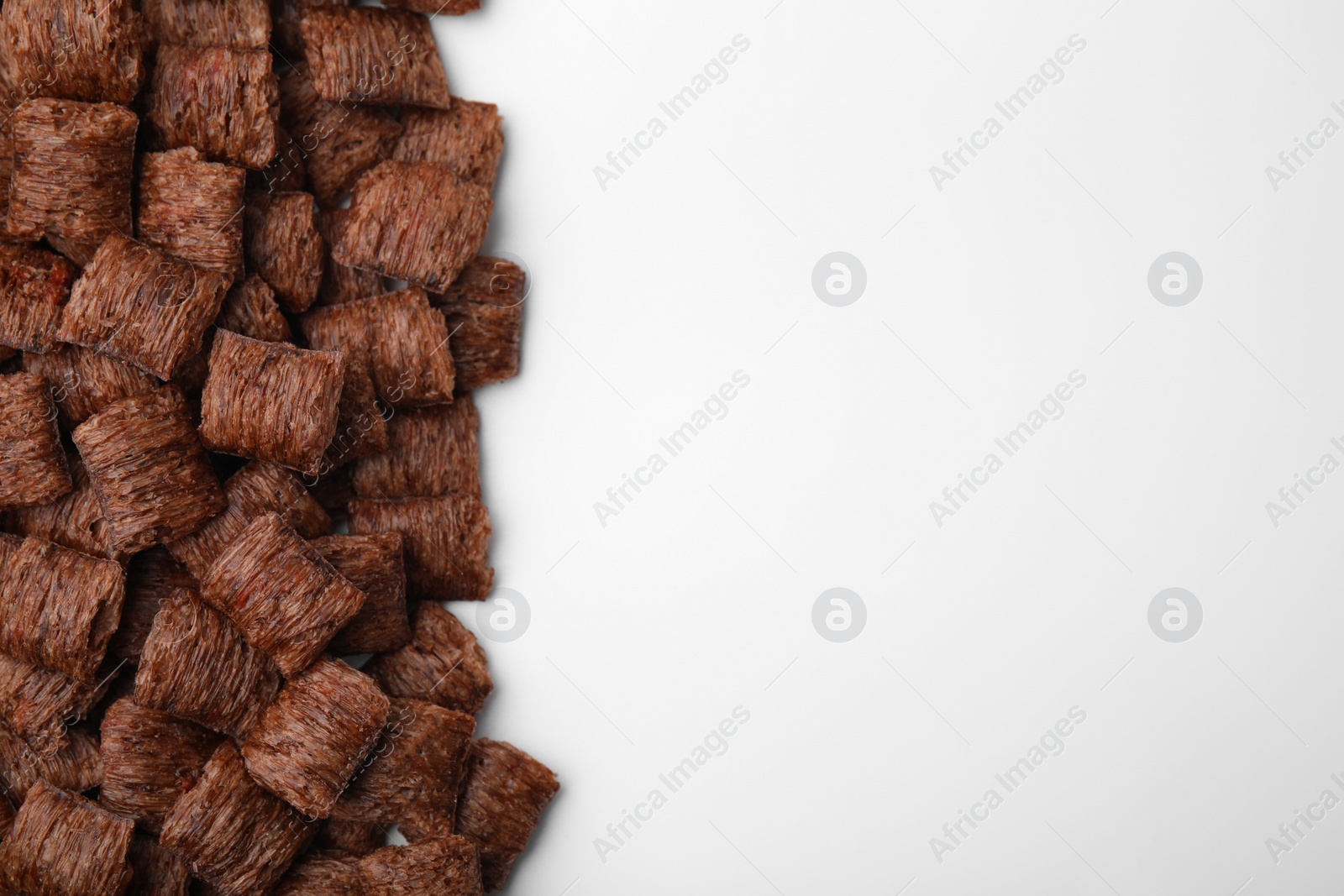 Photo of Chocolate cereal pads on white background, flat lay. Space for text