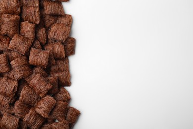 Photo of Chocolate cereal pads on white background, flat lay. Space for text